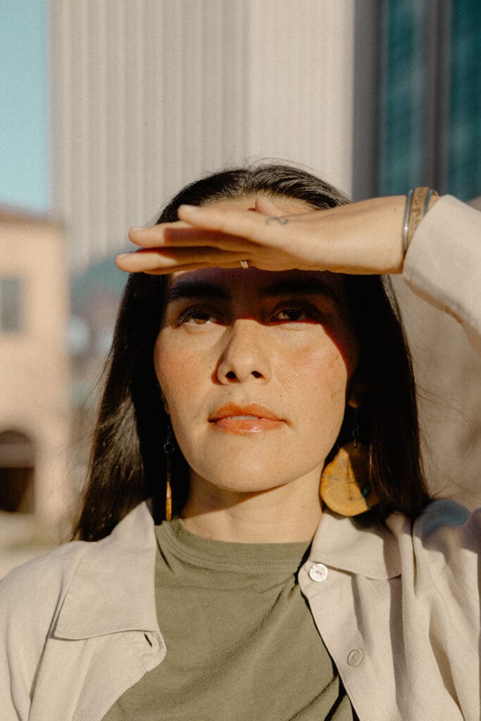 Close-up desert portrait with hand shielding eyes from the low Tucson sun