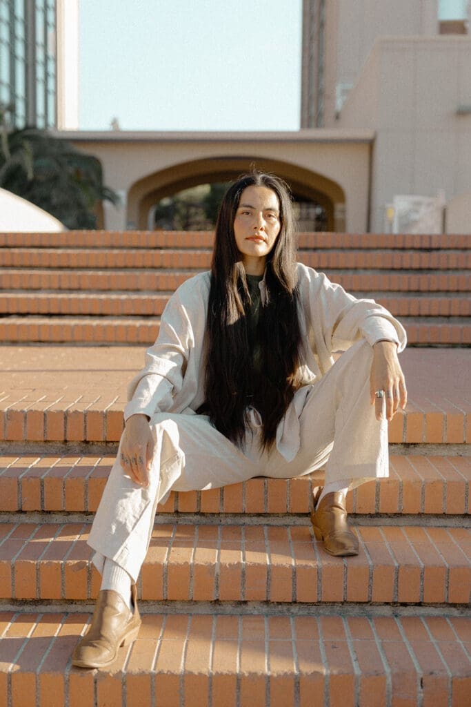 Relaxed lifestyle portrait seated on brick steps in soft desert light in Tucson