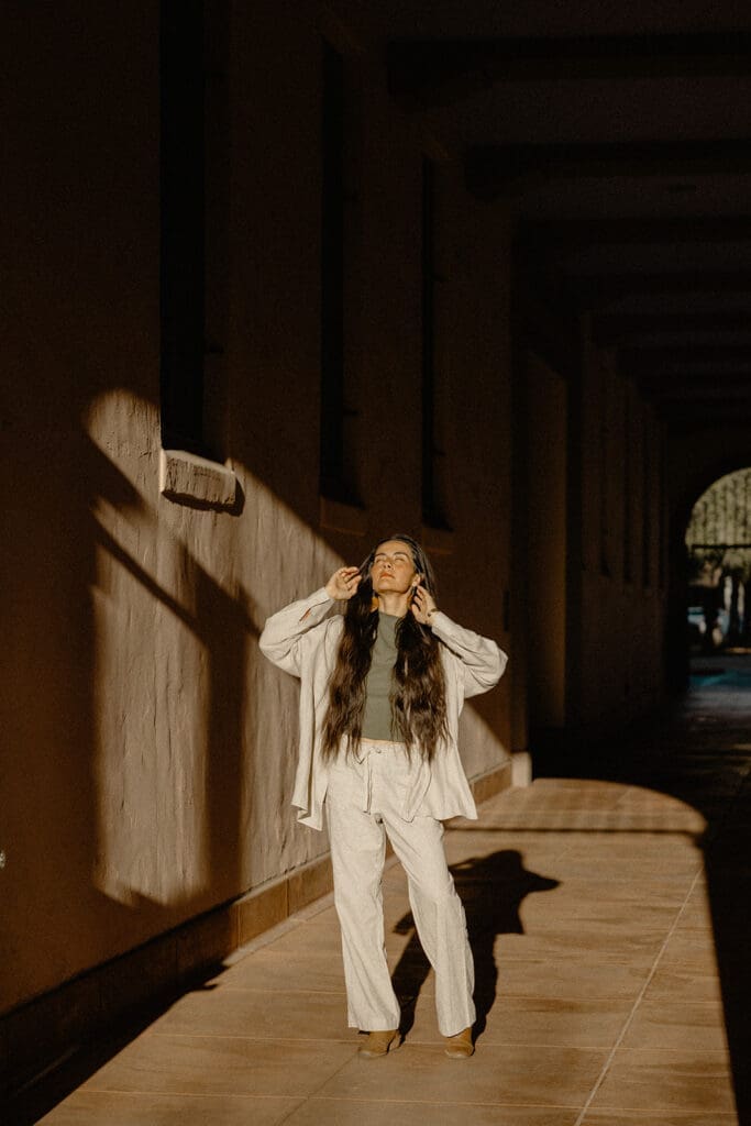 Tucson lifestyle session walking through a sunlit adobe corridor