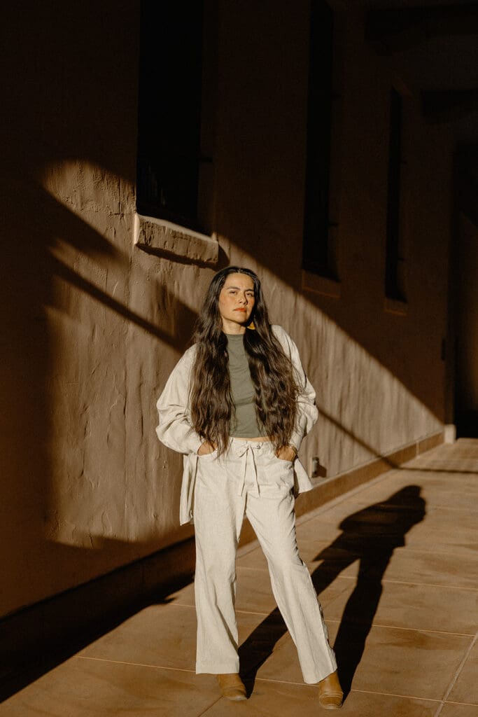 Tucson lifestyle session walking through a sunlit adobe corridor